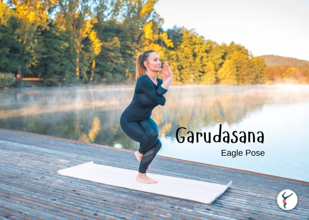 Woman practicing Garudasana (Eagle Pose) yoga outdoors by water.