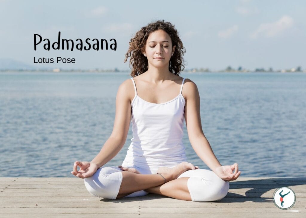Woman practicing Padmasana (Lotus Pose) by the water for yoga meditation and relaxation.