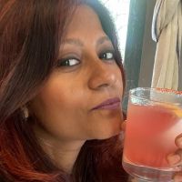 Group Online Yoga Classes for Everyday Fitness – Perfect for Beginners! - Plattershare - Recipes, food stories and food lovers Woman enjoying a pink cocktail during a yoga session at home.