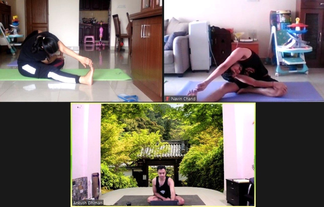 Group Online Yoga Classes for Everyday Fitness – Perfect for Beginners! - Plattershare - Recipes, food stories and food lovers Young woman practicing yoga on a green mat indoors, stretching forward in a seated pose.